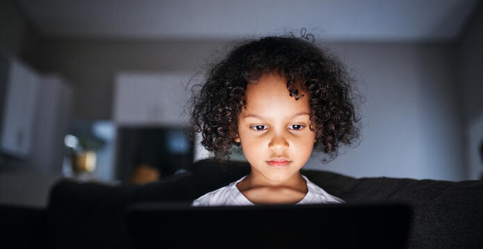 Child face illuminated over laptop