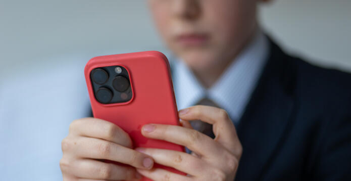 School pupil using mobile phone