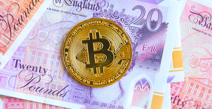 Bitcoin mockup resting on a pile of Bank of England banknotes