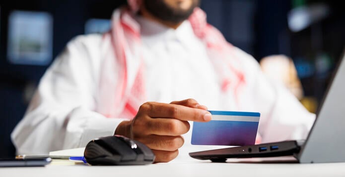 Middle Eastern man grasping a debit card
