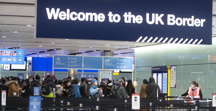 Passengers queuing at a UK Border control point