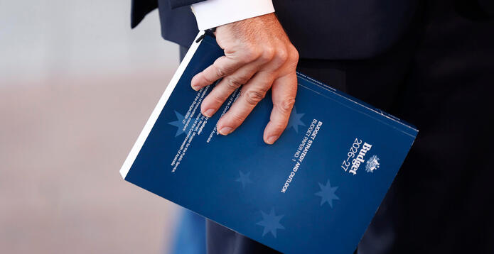 Treasurer Jim Chalmers holds a copy of the 2026 budget