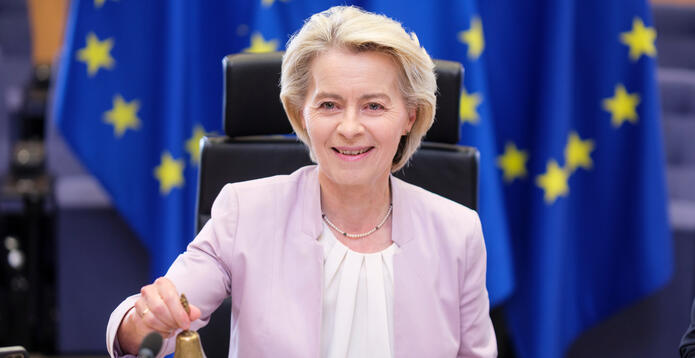 Ursula von der Leyen sitting before EU flags_Digital - Website - Standard ImageCard (1)