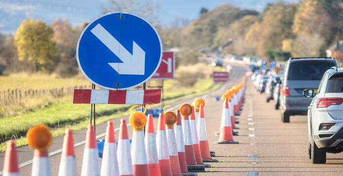 Traffic jam road works congestion with a queue of cars and traffic cones on motorway