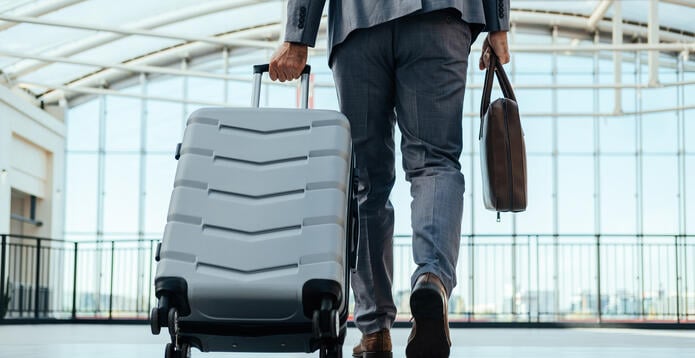Person walking through the airport with a suitcase