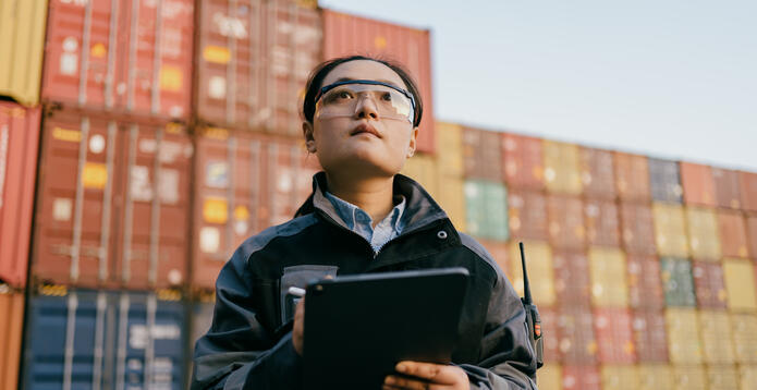 A supervisor checks shipping crates at a Chinese port