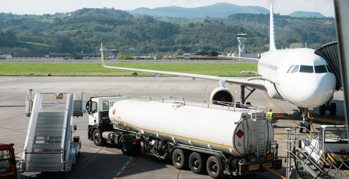 Fuel truck next to aircraft at airport