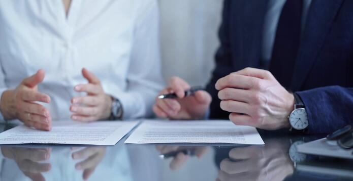 Business professionals reviewing and signing documents at a desk