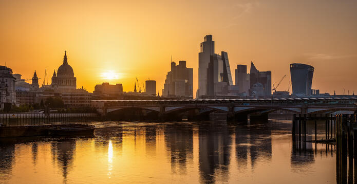 Golden summer sunrise view of the skyline of the City of London, England, with reflections in the River Thames. Photo: iStock