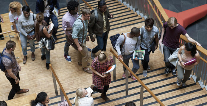 People moving up and down wooden stairs in a modern building