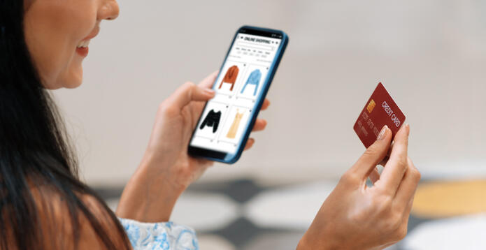 Young woman using smarpthone with credit card