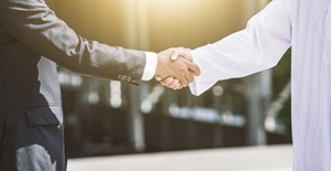 Businessmen shaking hands DIFC employment law Arabic man