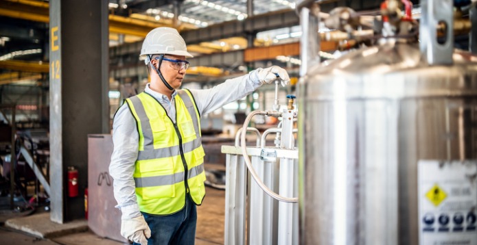 Asian worker operating a gas tank in a factory