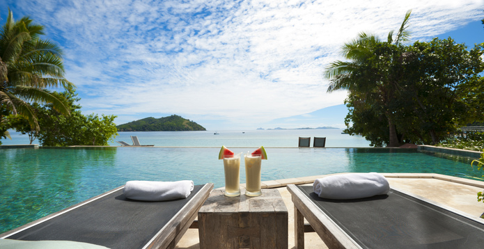 A lounge beside the pool with cocktails on table