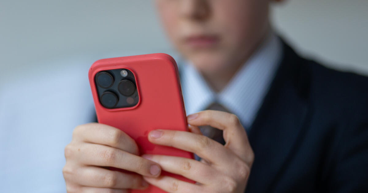 School pupil using mobile phone