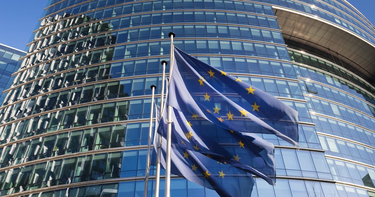 EU flags in front of glass building