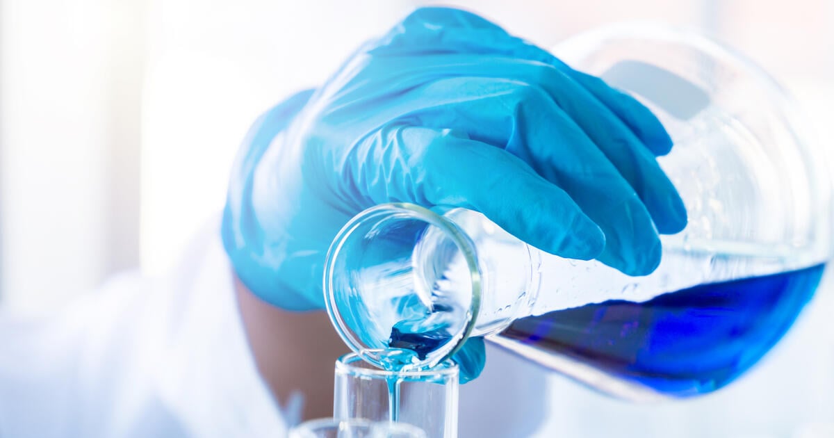 Scientist pouring chemical into test tube_Digital - SEOSocialEditorial image