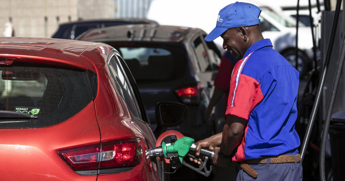 A petrol attendant fills a car