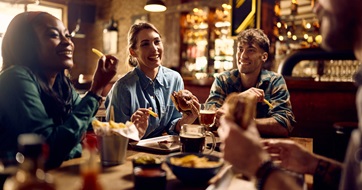 Friends celebrating in pub - iStock - unrestricted - seo