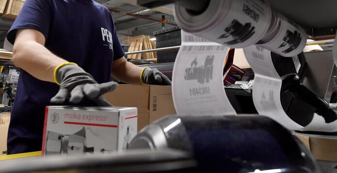 A staff member packs items in the packing area