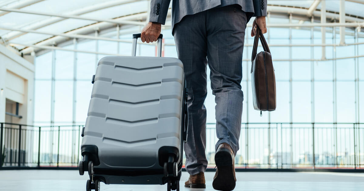 Person walking through the airport with a suitcase