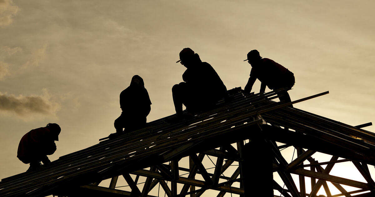 Contractor in Silhouette working on a Roof Top with Sky in background