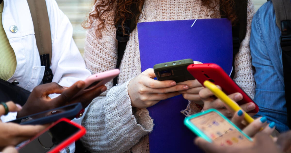Teenagers using social media on their cellphones
