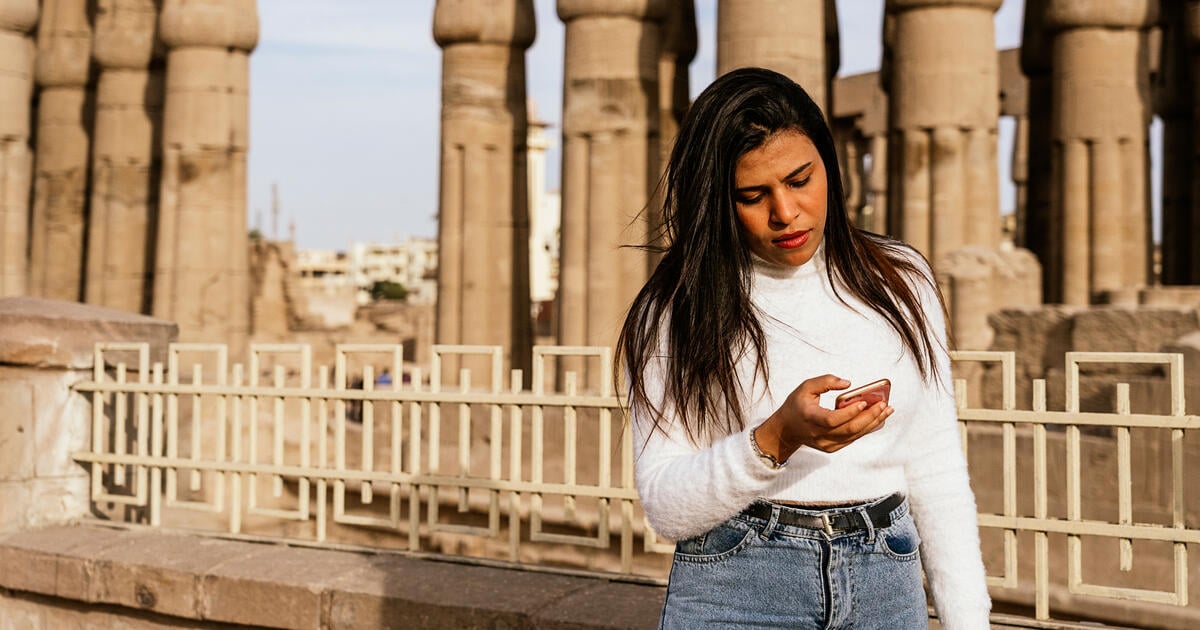 Portrait of a stylish modern contemporary successful Arab woman in urban setting during walking in summer day. Ruins of the temple of Luxor in the background. Photo: Royalty free via Getty Images