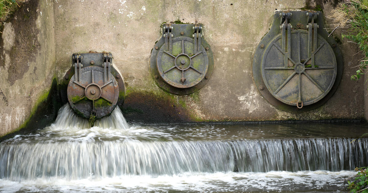Water discharges from an outlet pipe into the River Mersey in Manchester