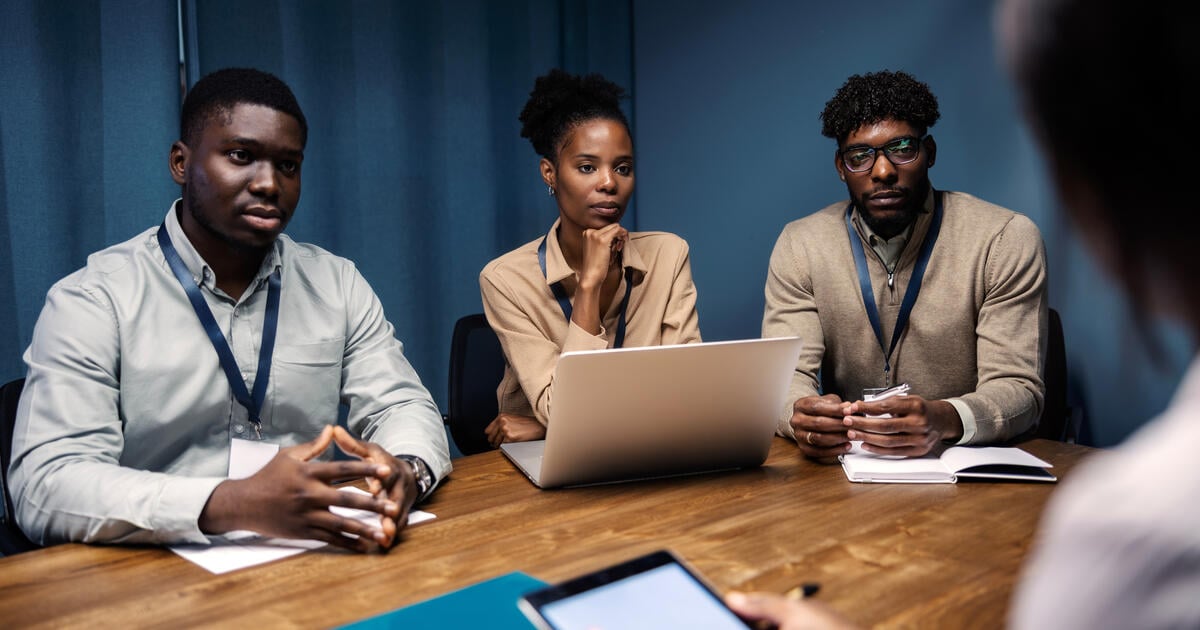 Group of young business professionals attentively listening to interview questions or presentation in a corporate office setting