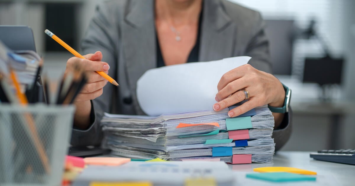 Woman searching documents in messy stack