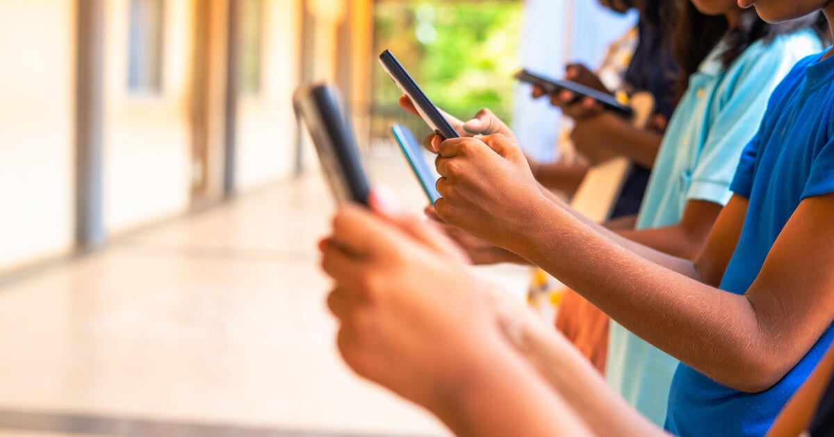 Hands of children using smartphones in corridor_Digital - SEOSocialEditorial image