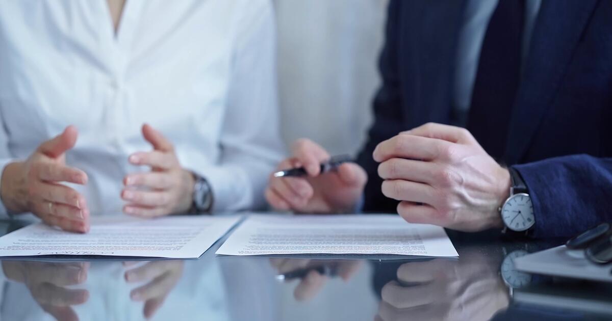 Business professionals reviewing and signing documents at a desk
