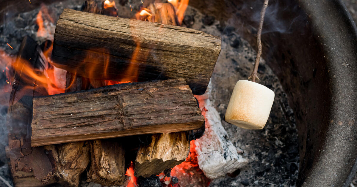 Roasting large marshmallow over campfire