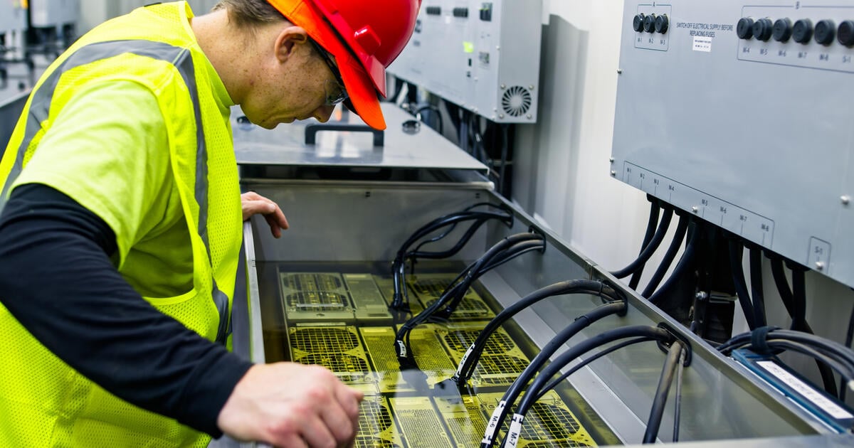 Technician Inspecting Server in Immersion Cooling Tank stock photo
