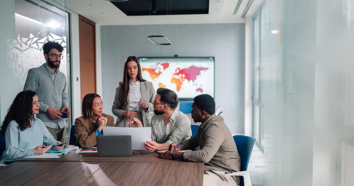 Group of diverse business people discussing global strategy during a corporate meeting in a modern conference room