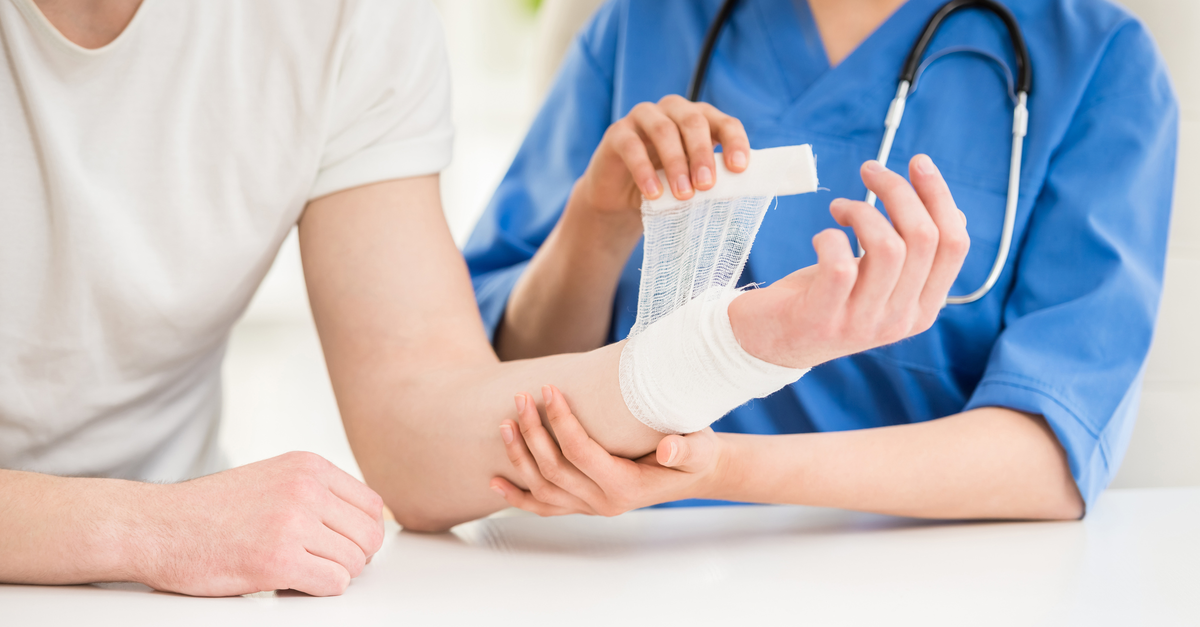 Healthcare doctor bandaging patient arm